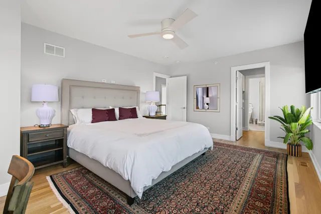 a bedroom with a large bed and a chandelier