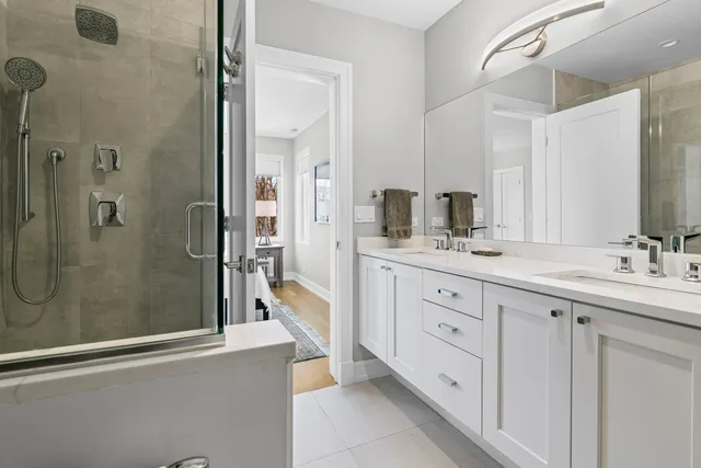 a bathroom with a double vanity sink toilet and shower