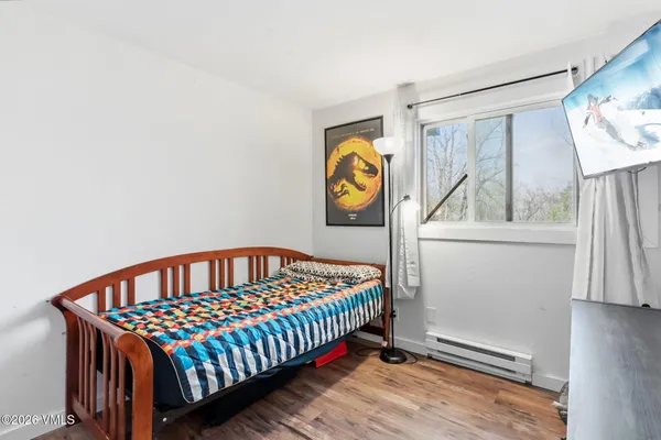 a bedroom with a bed and painting on the wall