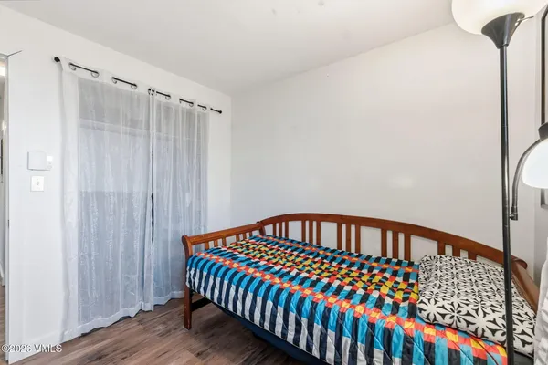 a bedroom with a bed and wooden floor