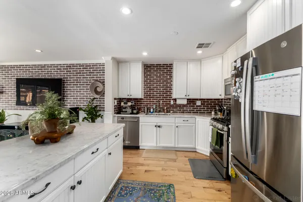 a kitchen with white cabinets and stainless steel appliances