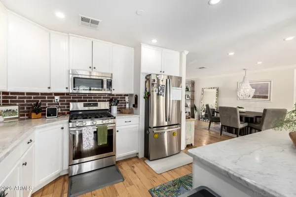 a kitchen with stainless steel appliances a stove a sink a refrigerator and cabinets