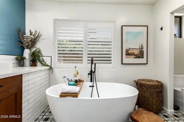 a white bath tub sitting in a bathroom next to a window