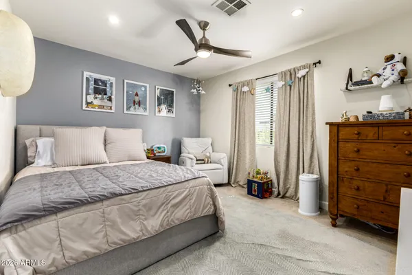 a spacious bedroom with a bed and a chandelier