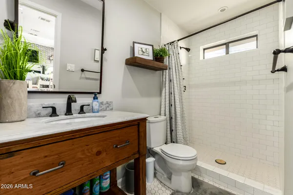 a bathroom with a granite countertop sink toilet and shower