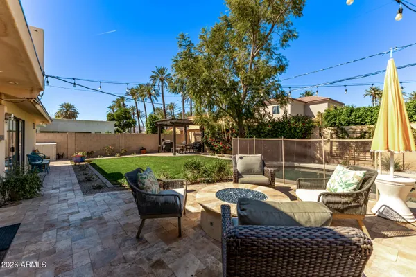 a view of a patio with couches chairs and a fire pit and two lawn chairs