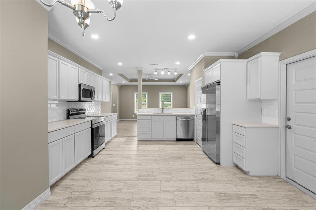 1011 Southeast County Road Corsicana, TX 75109 - Photo 10 of 40 a kitchen with white cabinets and stainless steel appliances