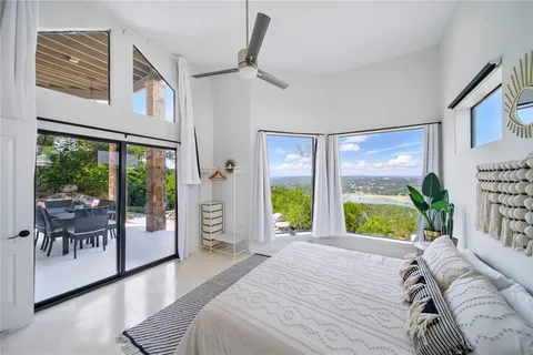 a bedroom with a bed and a large window with the outer view