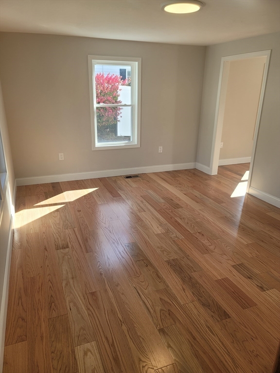 98 Uncatena Avenue, Unit L Worcester, MA 01606 - Photo 3 of 11 an empty room with wooden floor and windows