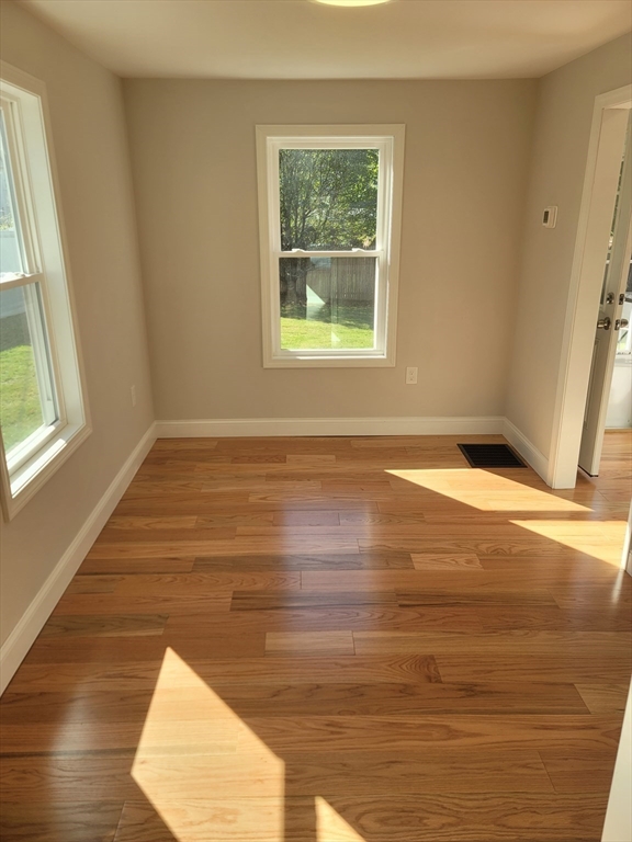 98 Uncatena Avenue, Unit L Worcester, MA 01606 - Photo 4 of 11 a view of an empty room with wooden floor and a window