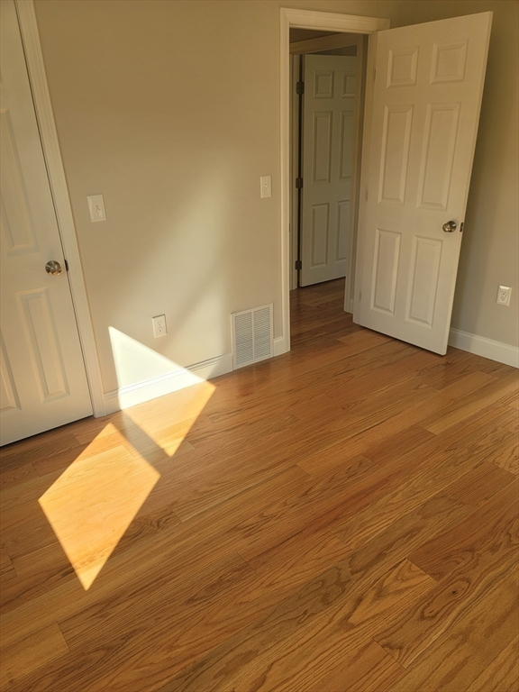 98 Uncatena Avenue, Unit L Worcester, MA 01606 - Photo 8 of 11 a view of an empty room and wooden floor
