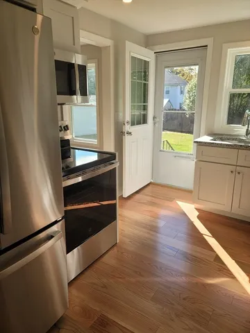 a view of kitchen with wooden floor and electronic appliances