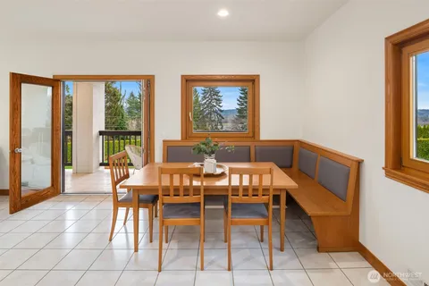 a view of a dining room with furniture and large windows