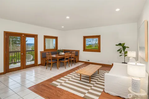 a living room with furniture a rug and a floor to ceiling window