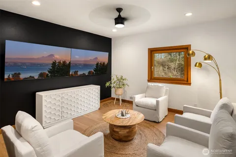 a living room with furniture a flat screen tv and a large window