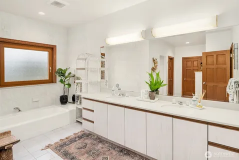 a bathroom with a granite countertop sink and a bathtub