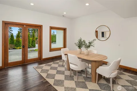 a dining room with chandelier and wooden floor