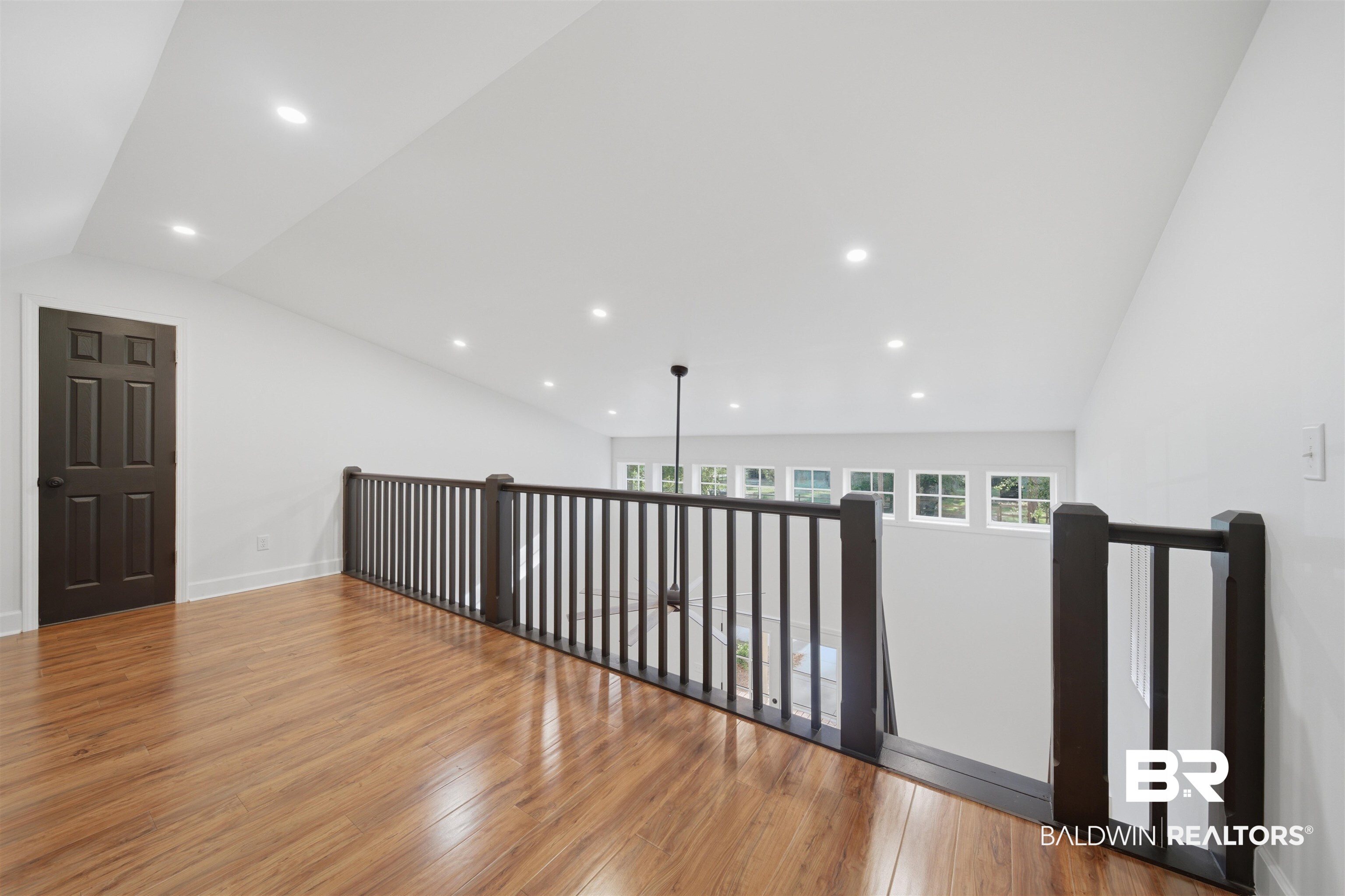 14128 Jackson Lane Foley, AL 36535 - Photo 29 of 36 Spacious loft area featuring wood-finish flooring, a dark wood-finish railing, recessed lighting, and white walls