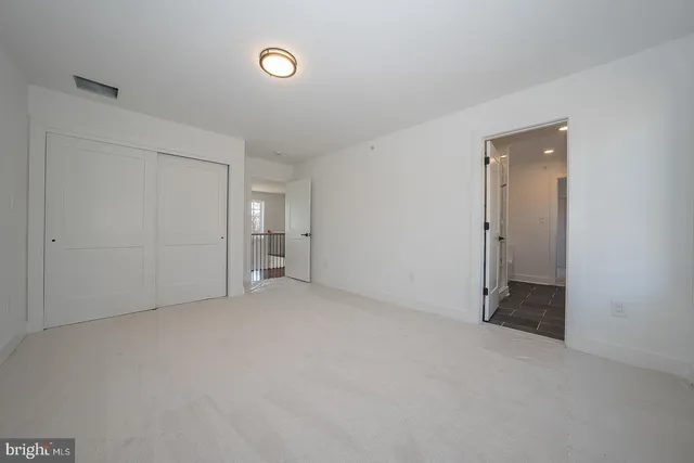 a view of an empty room and closet area