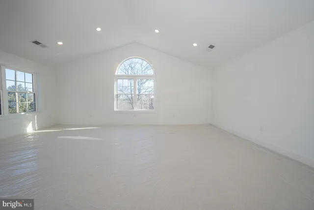 an empty room with windows and closet