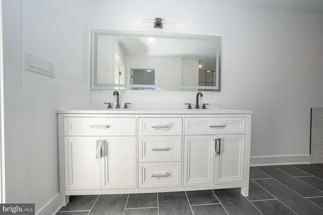 a bathroom with a sink vanity and mirror