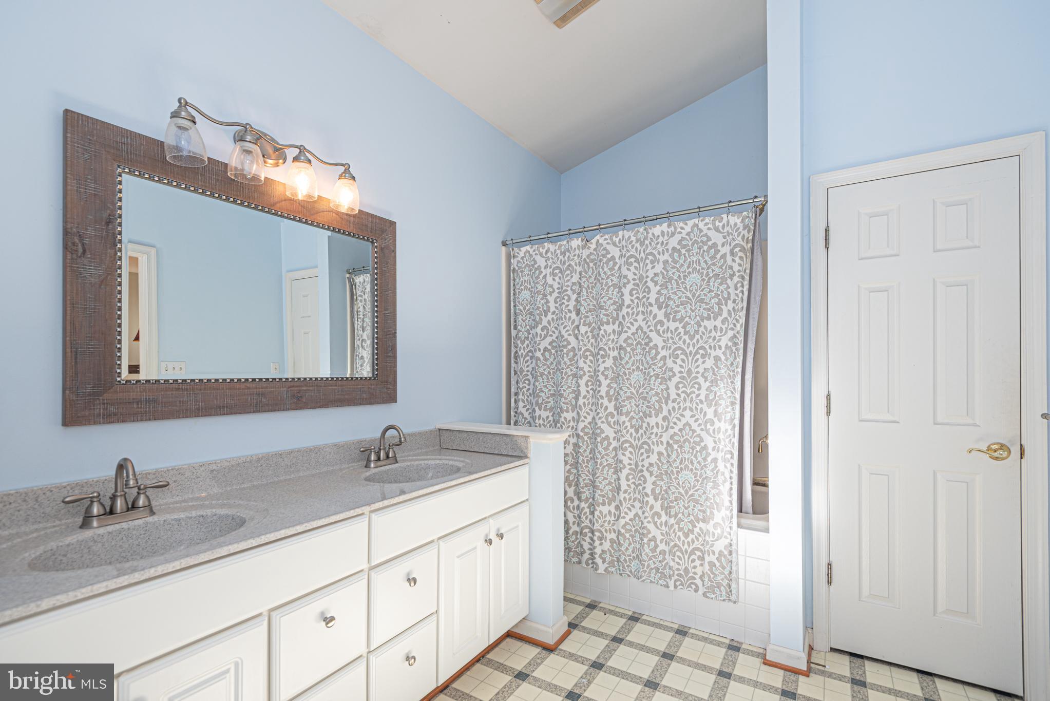 263 Oyster Shell Cove Bethany Beach, DE 19930 - Photo 20 of 50 a bathroom with a granite countertop sink a mirror and a shower