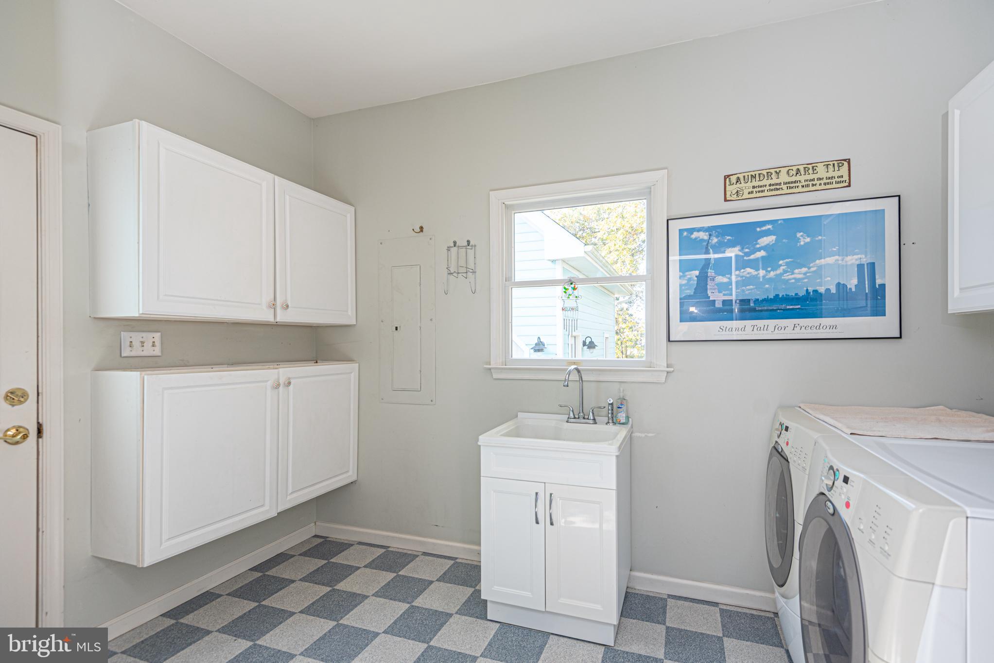 263 Oyster Shell Cove Bethany Beach, DE 19930 - Photo 33 of 50 a utility room with a sink a washer and dryer