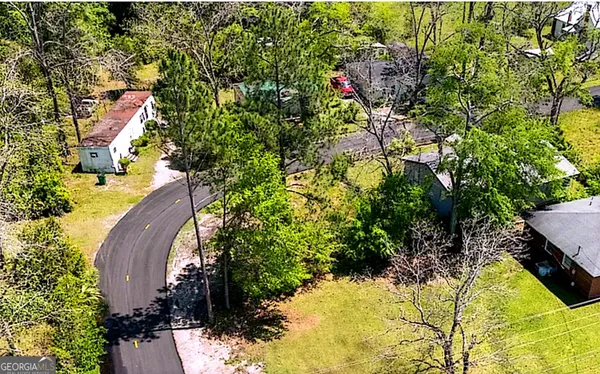 an aerial view of a house with swimming pool and garden