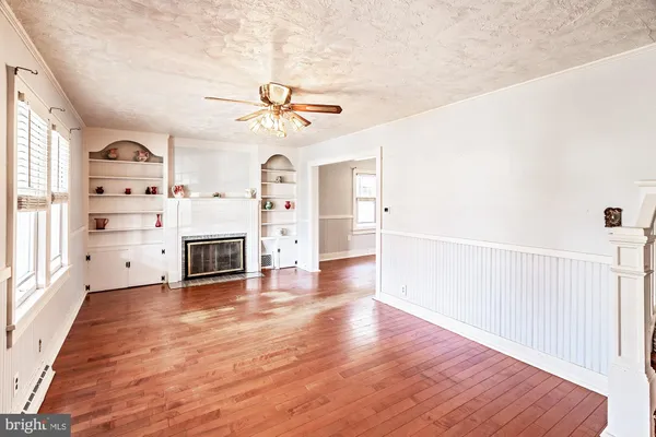a view of a livingroom with wooden floor and a ceiling fan