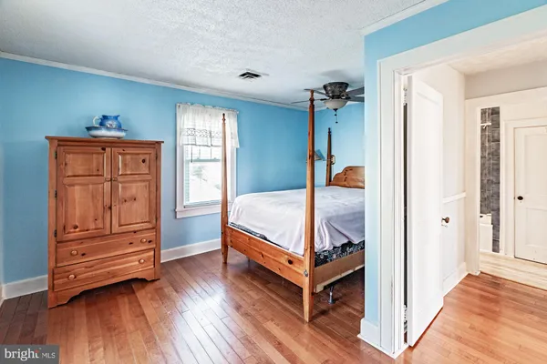 a bedroom with bed and wooden floor
