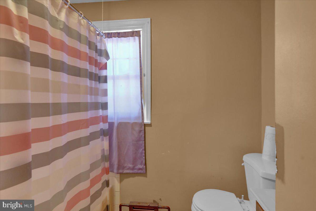 224 Hanley Place Reading, PA 19611 - Photo 13 of 19 a white toilet sitting next to a shower curtain