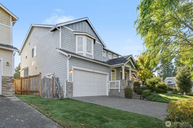 a front view of a house with a garden and trees