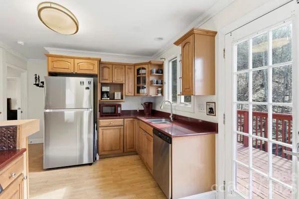 a kitchen with stainless steel appliances granite countertop a refrigerator a stove and a sink with large window