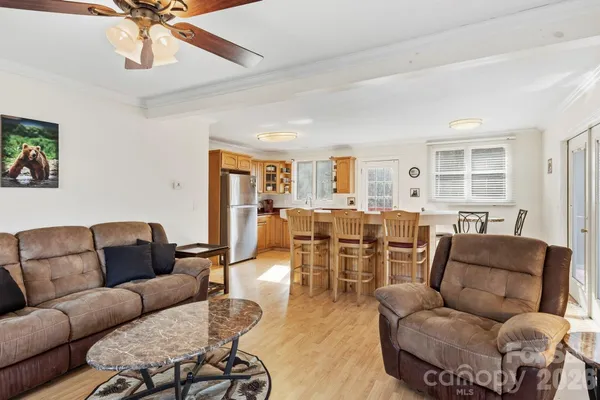 a living room with furniture kitchen view and a chandelier