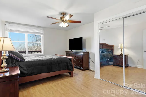 a bedroom with a bed and a flat tv screen on dresser