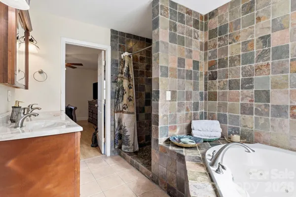 a bathroom with a tub sink toilet and shower