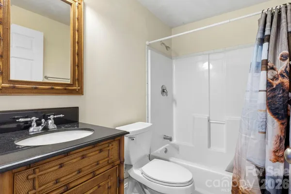 a bathroom with a granite countertop sink toilet a mirror and shower