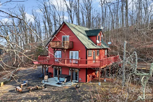 a front view of a house with large trees