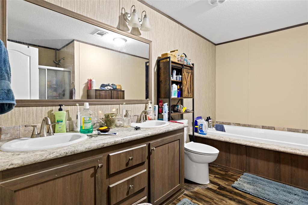 454 Geronimo Quitman, TX 75783 - Photo 25 of 37 a bathroom with a granite countertop sink a toilet and a mirror