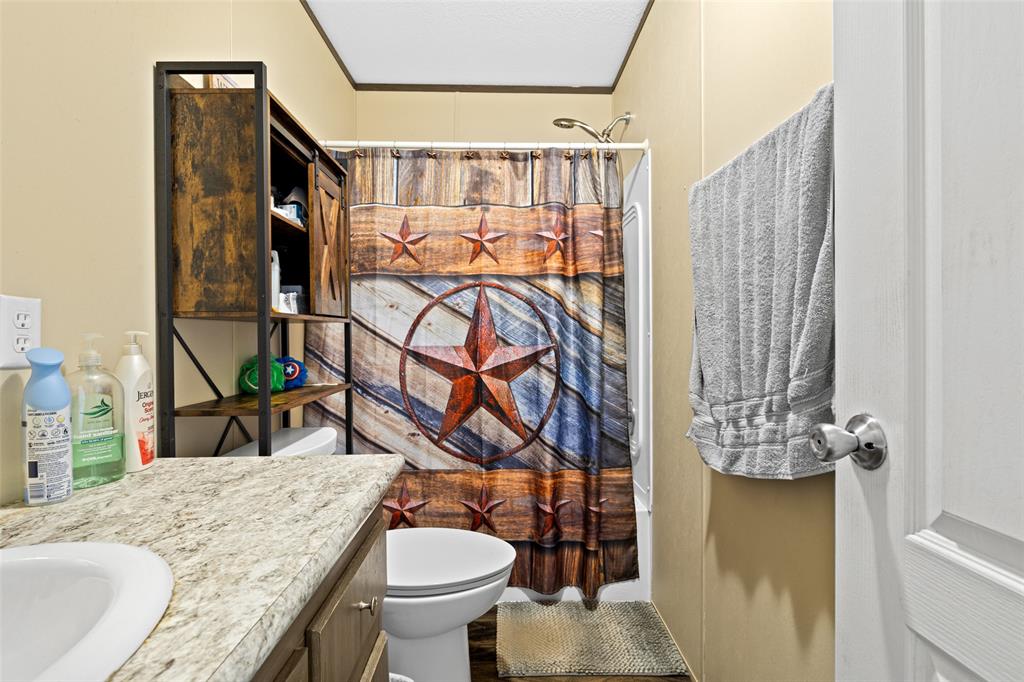 454 Geronimo Quitman, TX 75783 - Photo 28 of 37 a bathroom with a granite countertop sink and a mirror