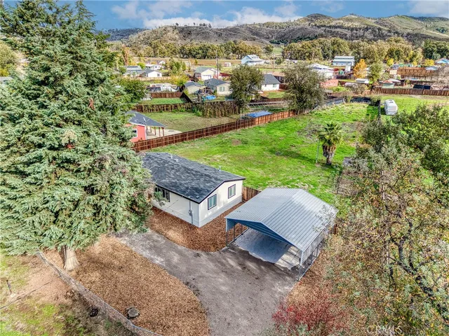 an aerial view of a house with a yard and lake view