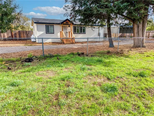 a view of a house with backyard and a tree