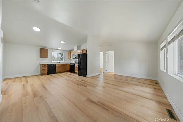 a view of empty room with wooden floor and window