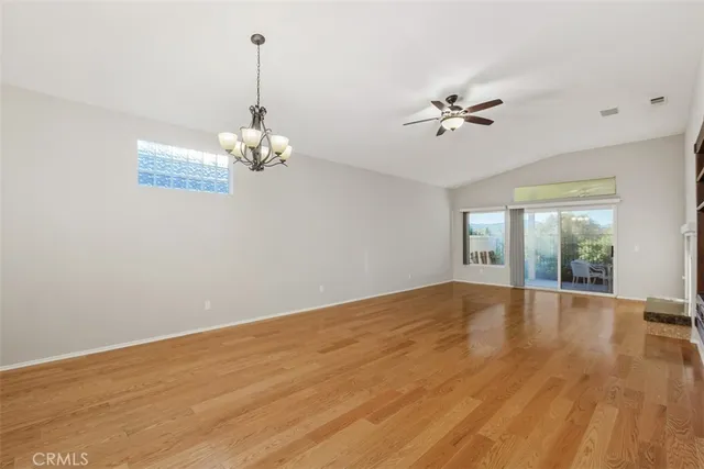 a view of a room with wooden floor chandelier and a window