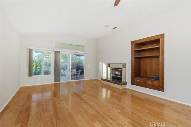 a view of an empty room with a window and fire place