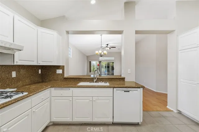 a kitchen with granite countertop a sink and cabinets
