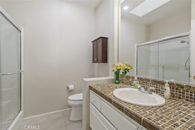 a bathroom with a granite countertop sink a toilet and a mirror