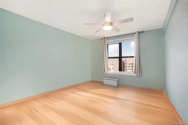 an empty room with windows and fan