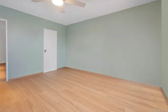 a view of an empty room with a chandelier fan
