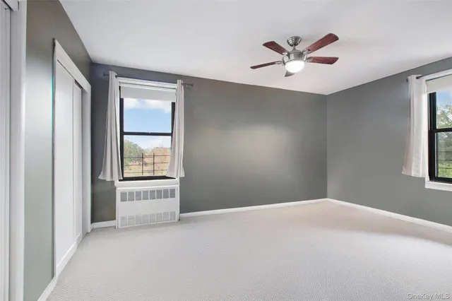 a view of a livingroom with a ceiling fan and window